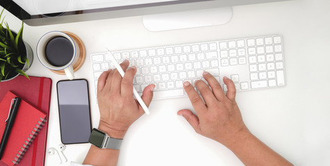 Top view of young businessman typing on keyboard computer in modern office room