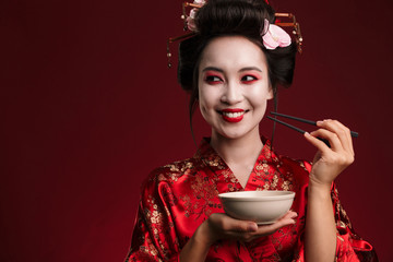 Canvas Print - Image of geisha woman in japanese kimono holding bowl plate and chopsticks