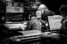 Professional Male Producer, Director, Editor, Composer Working With Sound Engineer In Recording Studio. Music Production Concept