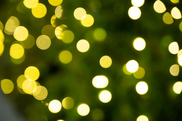 Defocused of yellow bokeh blurred circle light from lighting bulb Merry Christmas   and Happy New Year decorative in the night for abstract background texture