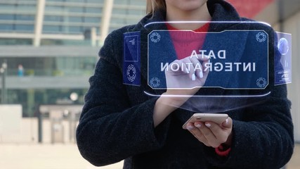 Unrecognizable woman interacts HUD hologram with text Data integration. Girl in the coat uses the technology of the future mobile screen on the background of the city