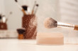 Professional brush of makeup artist and powder on dressing table