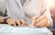 © panitan - high school,university student study.hands holding pencil writing paper answer sheet.sitting lecture chair taking final exam attending in examination classroom.concept scholarship for education abroad