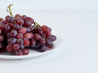 Wall Mural - Bunch of grapes on white plate.