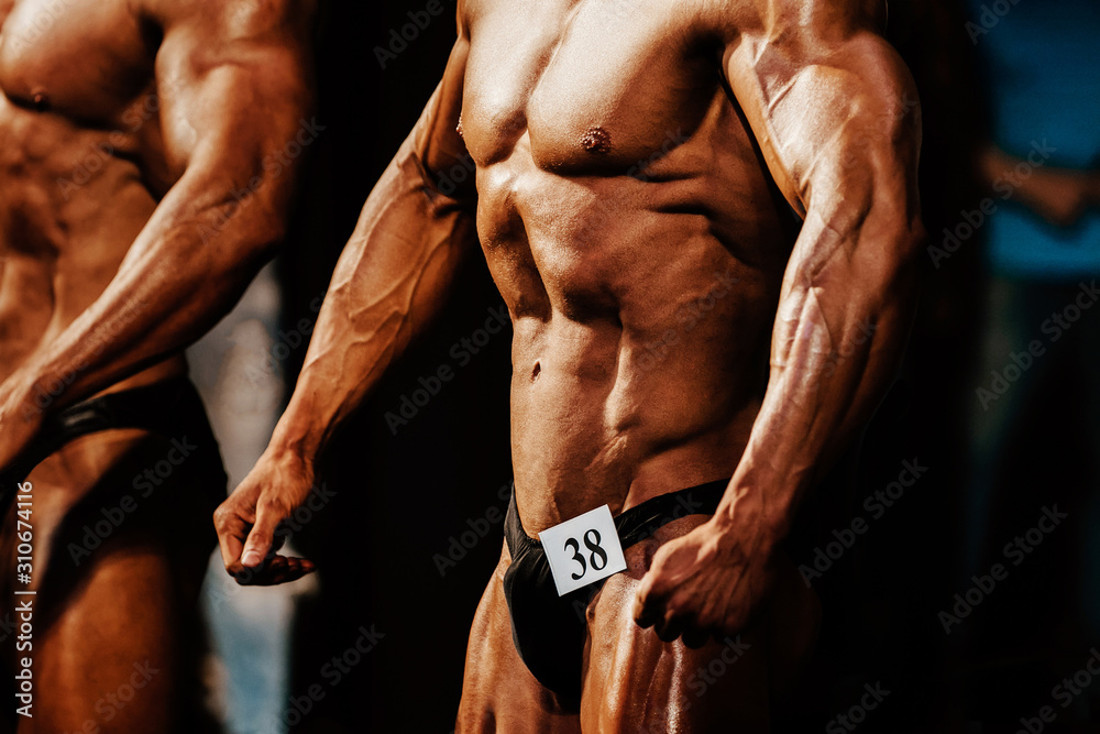 athlete man bodybuilder posing chest muscles and abs bodybuilding competition - obrazy, fototapety, plakaty 