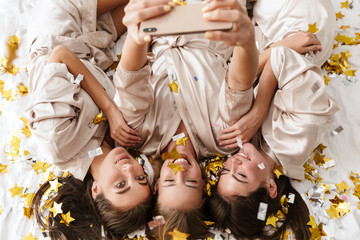 Poster - Girls women friends indoors on bed at the hen party