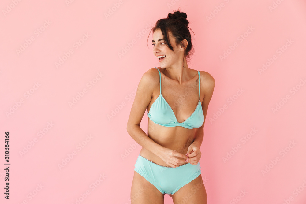 Beautiful young slim girl wearing bikini standing isolated - obrazy, fototapety, plakaty 