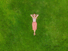 Young Woman Lying Down In The Middle Of A Field And Relaxing, Drone Photo