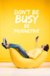 man relaxing on bean bag chair and using smartphone on yellow background with dont be busy, be productive illustration