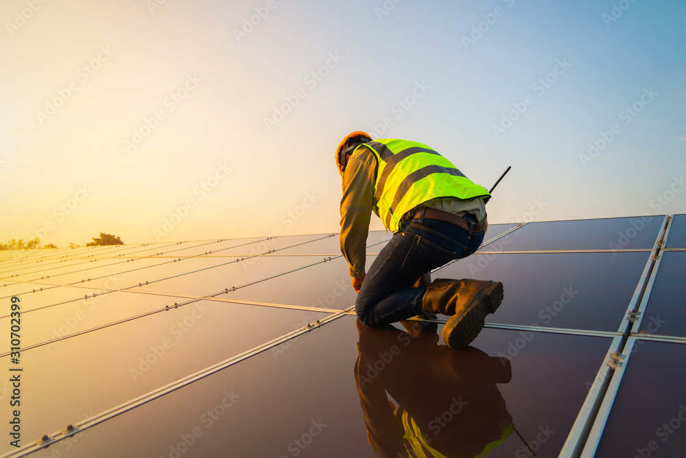 Portrait of engineer man or worker, people, with solar panels or solar cells on the roof in farm. Power plant with green field, renewable energy source in Thailand. Eco technology for electric power. - obrazy, fototapety, plakaty 