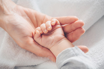 close-up baby hand on mother's hands