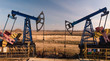 © Danil Nevsky/Stocksy - Oil pumpjacks over wells in evening