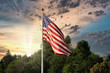 sunset and weather with cloudy sky behind american flag blowing in the wind