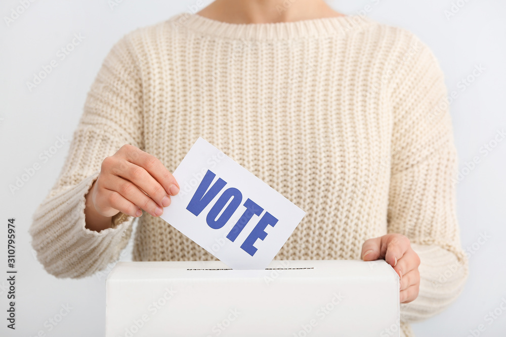 Voting woman near ballot box on light background