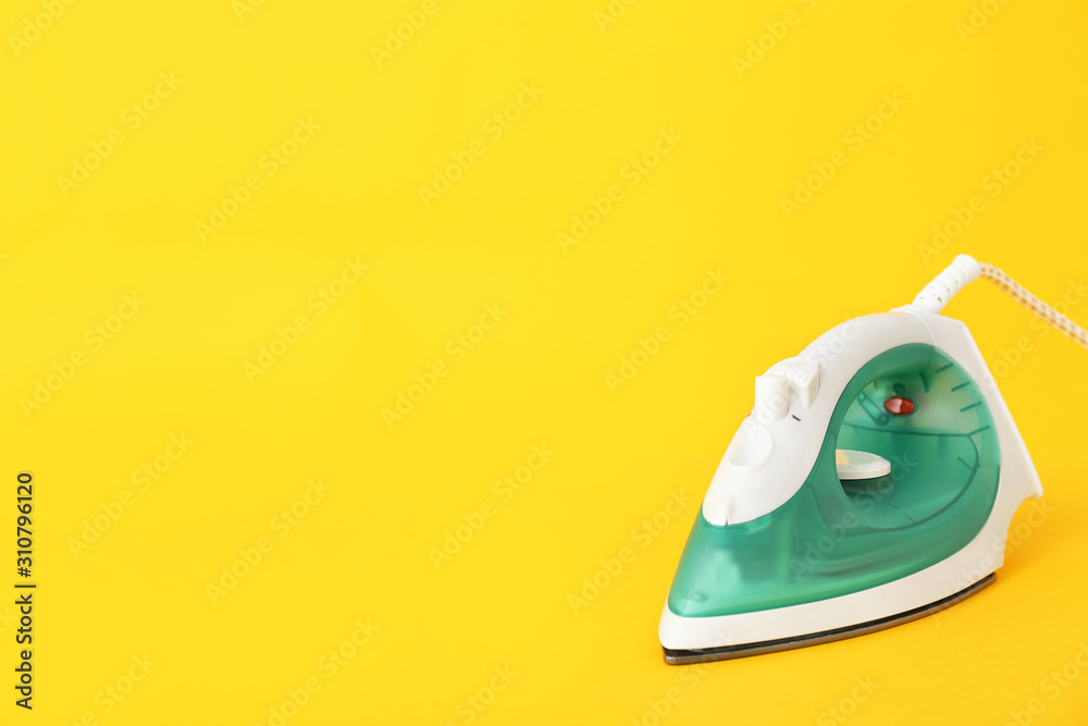 Electric iron on color background