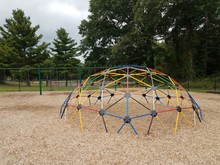 Colorful Metal Jungle Gym On Playground With Wood Chips