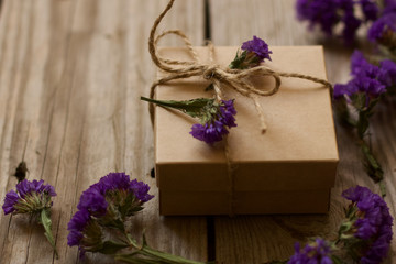 gift box with wild flowers decoration. craft gift box on wooden background. vintage style