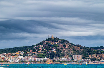 Wall Mural - Blanes Castle, from the beach, with clouds threatening rain