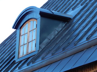 Window with a visor on the roof of the building