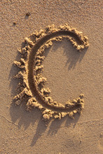 Alphabet (c) Letters Handwritten In Sand On Beach