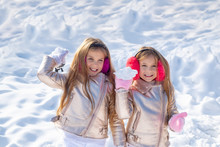 Little Girls Throw Snowball In Park. Portrait Of Two Little Girls Play With Snow In Winter. Cute Sisters Playing In A Snow. Winter Children Posing And Having Fun. Woman Kids Portrait.