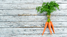 Fresh Carrots On A White Wooden Background. Top View. Free Space For Your Text.