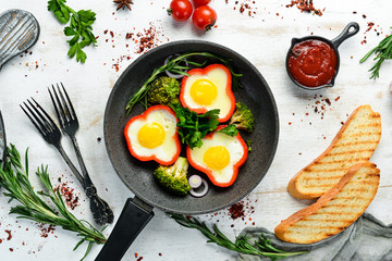 Fried egg with sweet pepper on a black plate. Top view. Free copy space.