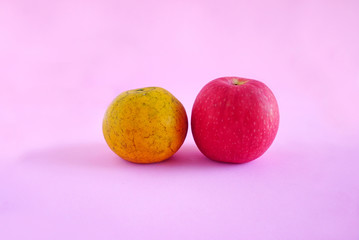 Wall Mural - Orange and apple isolated on the pink scene or pink background