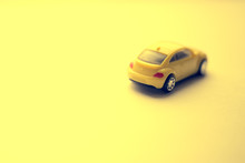 Unfocused Yellow Toy Car On The Yellow Space.