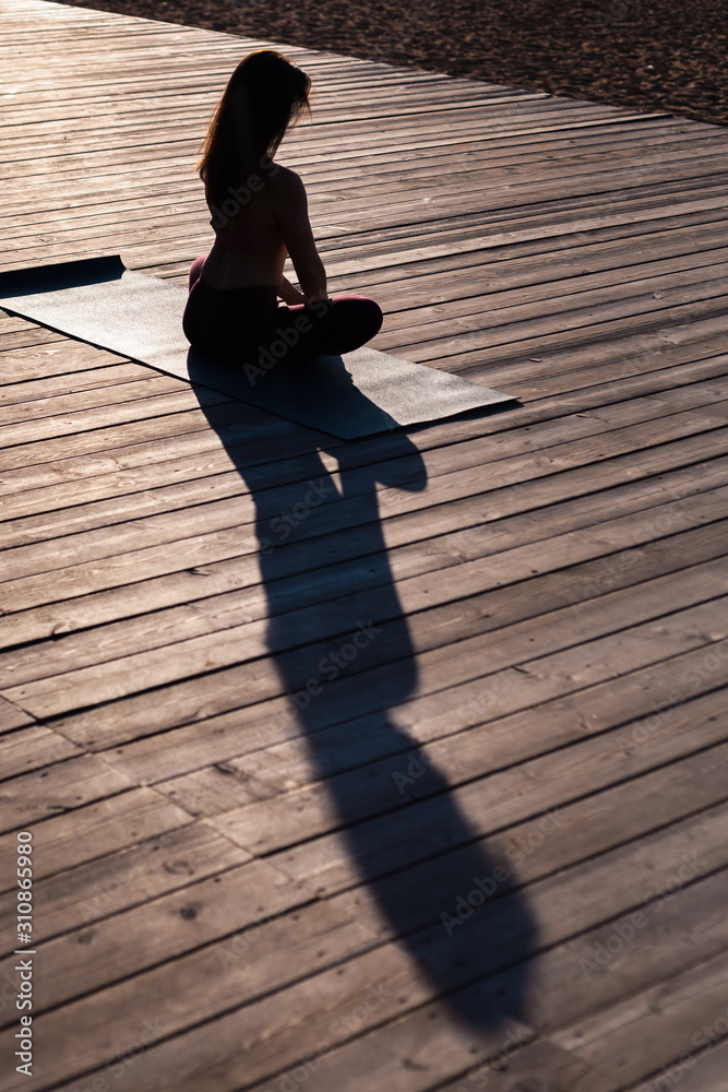 silhouette of slender beautiful girl practice sukhasana yoga asana on a ...