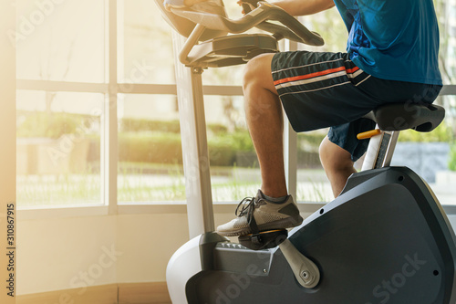 Close up of a man exercise in gym, Cycling on bike in fitness gym