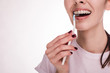 © 58production - Close up and cut view of interdental brush in young woman's hand. Cleaning teeth and braces. Dental care. Modern technique. Rubber bands for braces. Young woman isolated.