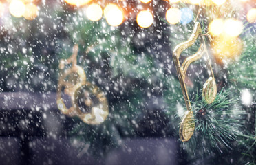 Wall Mural - Music note decoration on christmas tree with snow falling in the winter