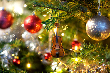 Violin in christmas tree decoration with red and silver baubles