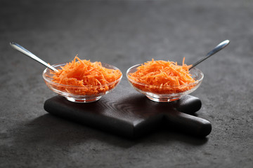 Still life with carrots on a dark background, vegetable salad with carrots, grated carrots