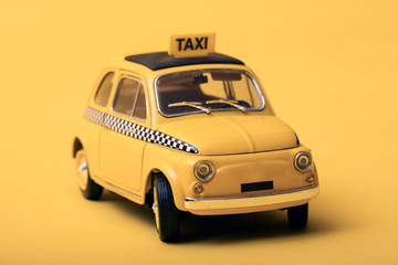 Yellow retro toy taxi on yellow background