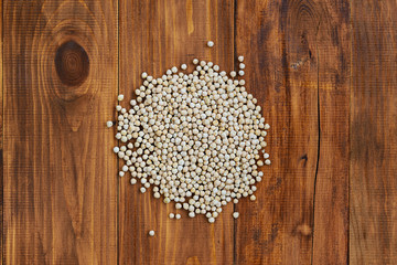 A pile of chickpeas on a brown wooden table.