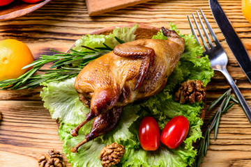 Wall Mural - Serving board with whole baked quails in a rustic wooden setting