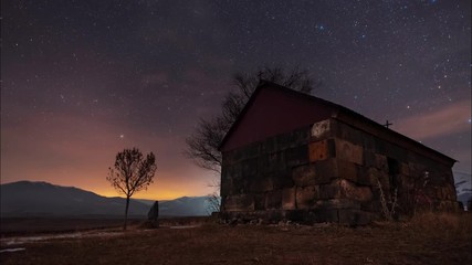 Wall Mural - Beautiful night landscape, small church and star trails. The colorful star on the sky with orientation on the north star. Night time lapse.