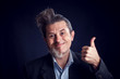 © Aleksej - Half bearded man wearing suit showing thumb up gesture in front of black background. People and skin care concept