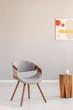© Photographee.eu - Stylish grey wooden chair in empty living room interior with trendy wooden coffee table