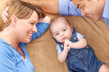 Wall Mural - Young Mixed Race Couple Laying With Their Infant On A Blanket