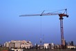 © Nawat - Red steel construction crane with building in city background and blue sky light sunset
