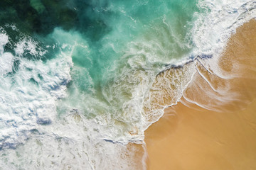 Wall Mural - View from above, stunning aerial view of some waves crashing onto a beautiful beach during sunset. Nyang Nyang Beach (Pantai Nyang Nyang), South Bali, Indonesia.