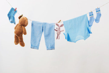 Wall Mural - baby clothes hanging on  rope on white background