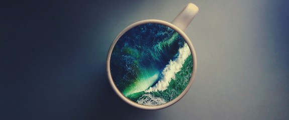 White cup with water. Sea. Ocean. Sea waves. Creative postcard.