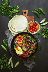 Grilled skirt steak and stir fried vegetables fajitas, top down view