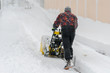 © jollier_ - man operating snow blower to remove snow on driveway. Man using a snowblower. A man cleans snow from sidewalks with snowblower