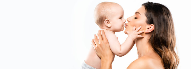panoramic shot of happy naked mother kissing adorable baby, isolated on white