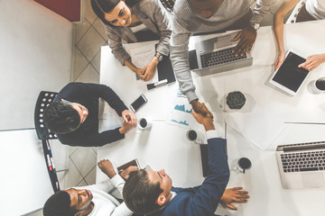 Wall Mural - A team of young office workers, businessmen with laptop working at the table, communicating together in an office. Corporate businessteam and manager in a meeting. coworking.